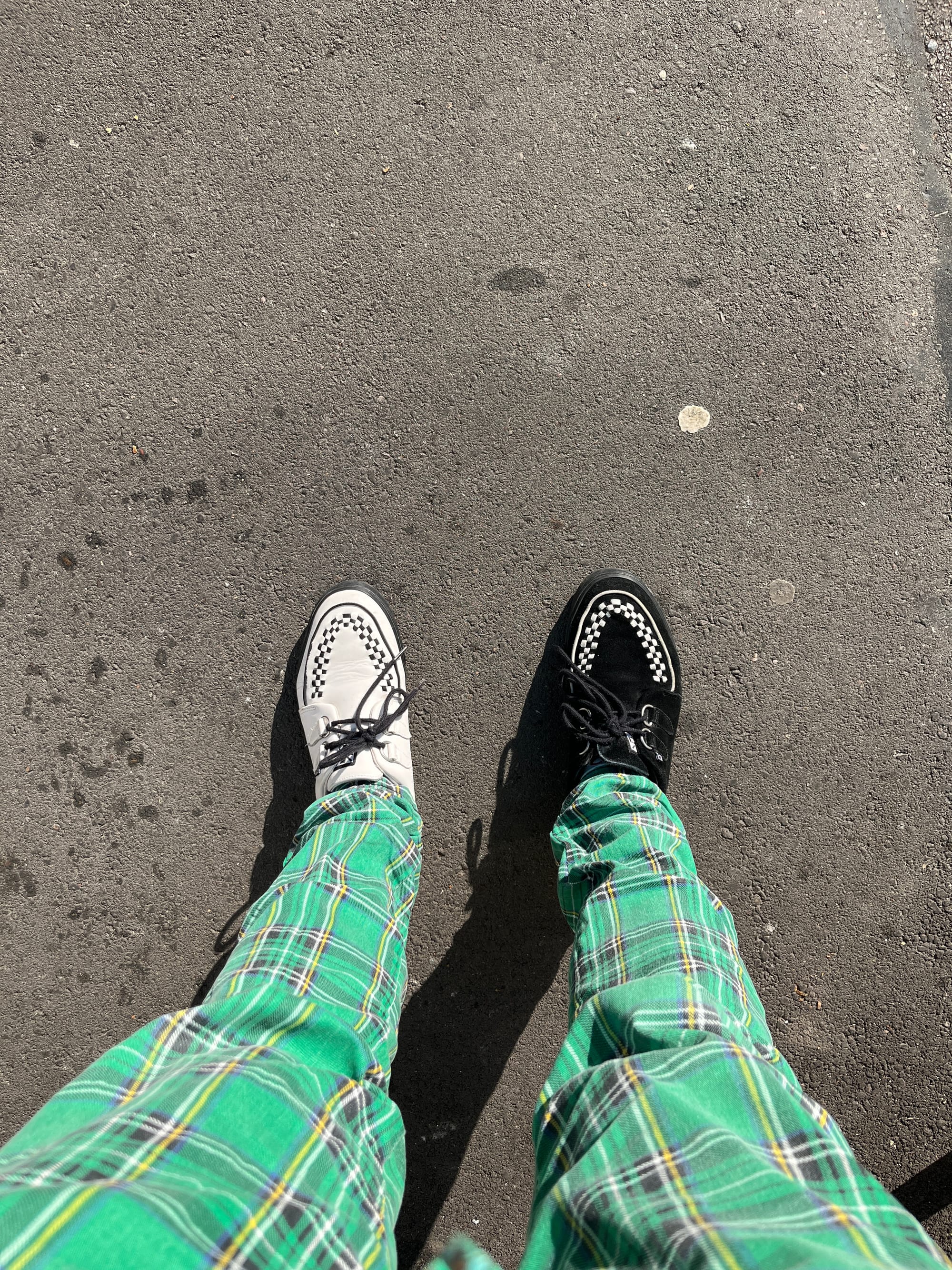 On my left foot, a white shoe with a black pattern. On my right foot, a black shoe with the same pattern in white. And my green plaid pants.